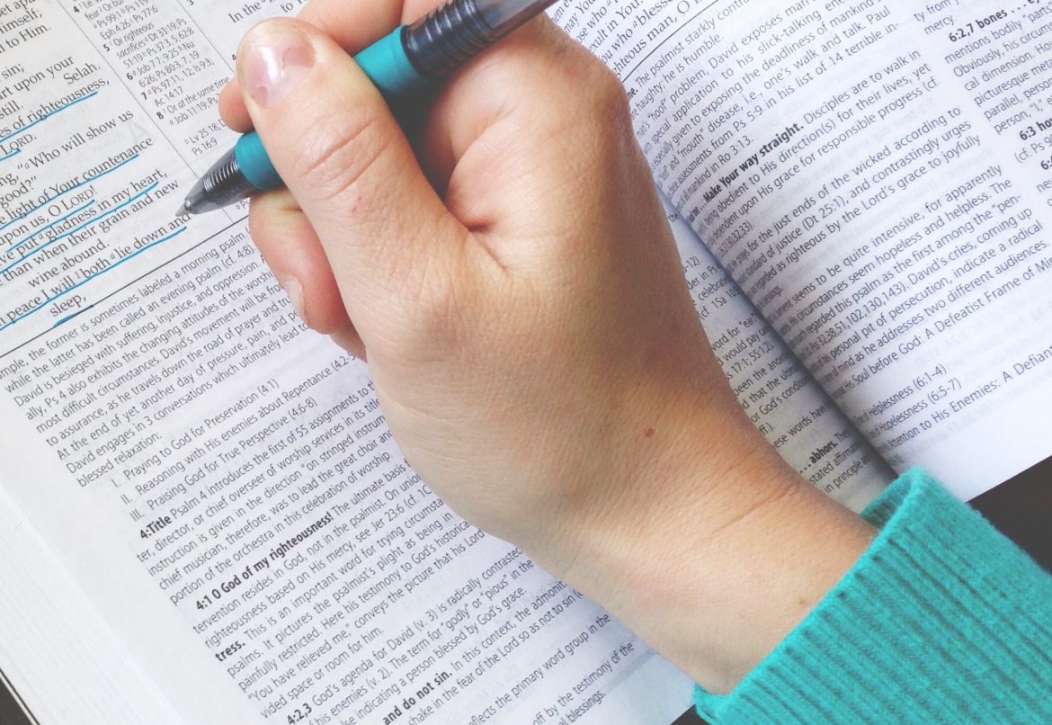 woman writing in bible